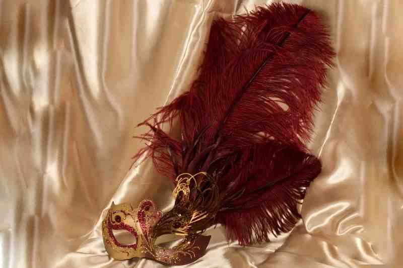 Paper mache Venetian mask with filigree detail and luxury tall feathers in gold and red