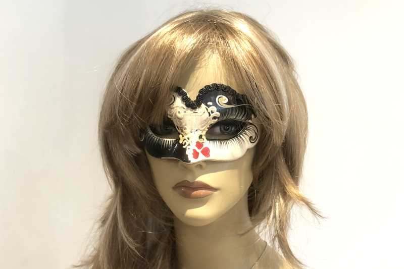 small masquerade mask with heart decoration shown on female face