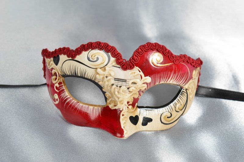 small masquerade mask with heart decoration in red